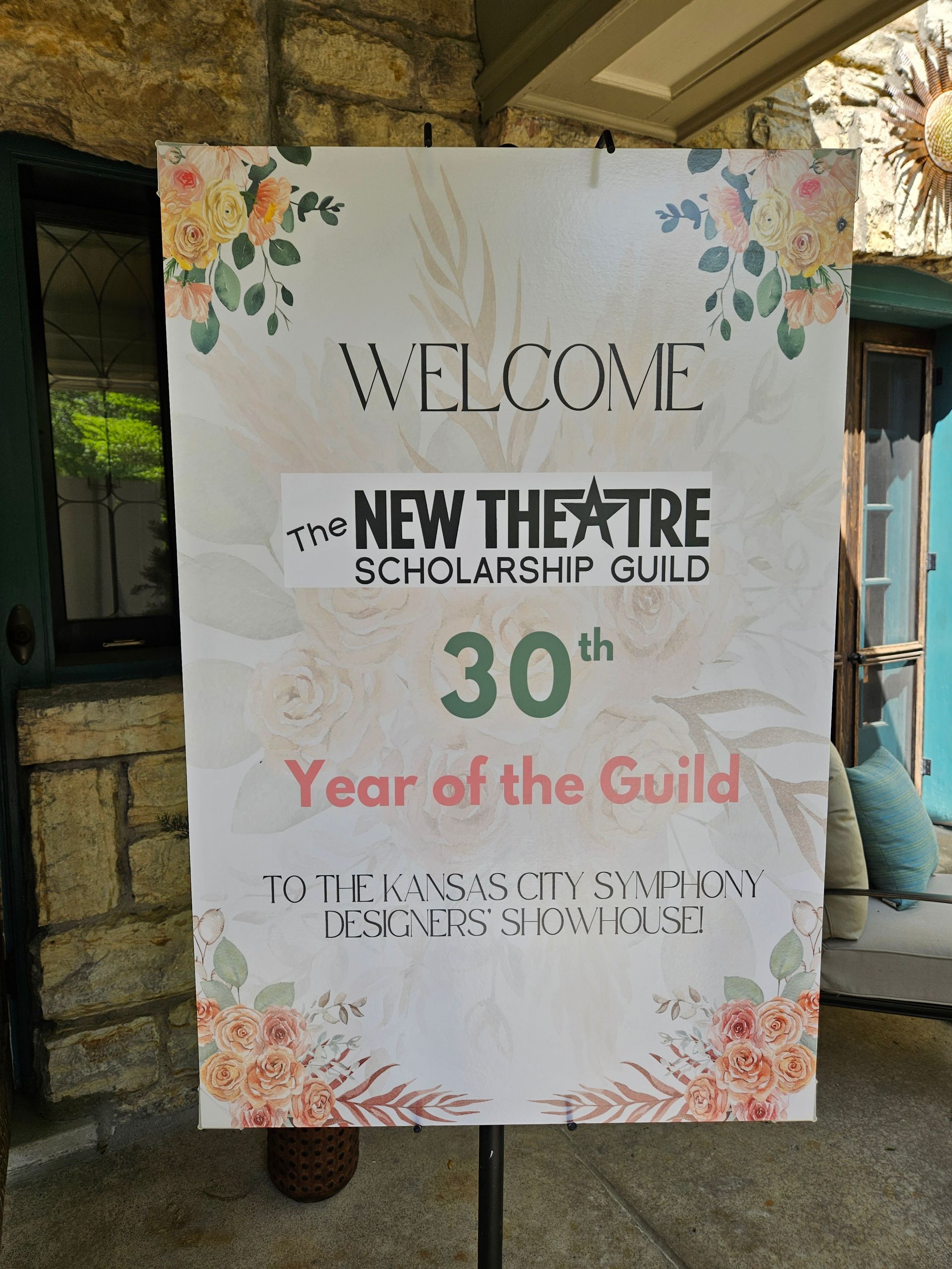 Welcome sign: New Theatre Scholarship Guild 30th Year of the Guild, pink and floral design on white banner.