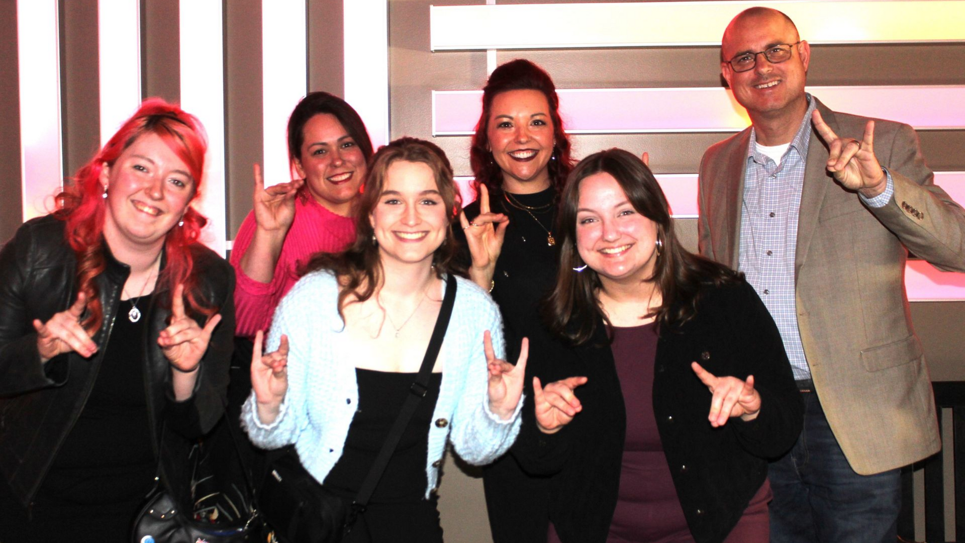 Group of six people posing and flashing the 