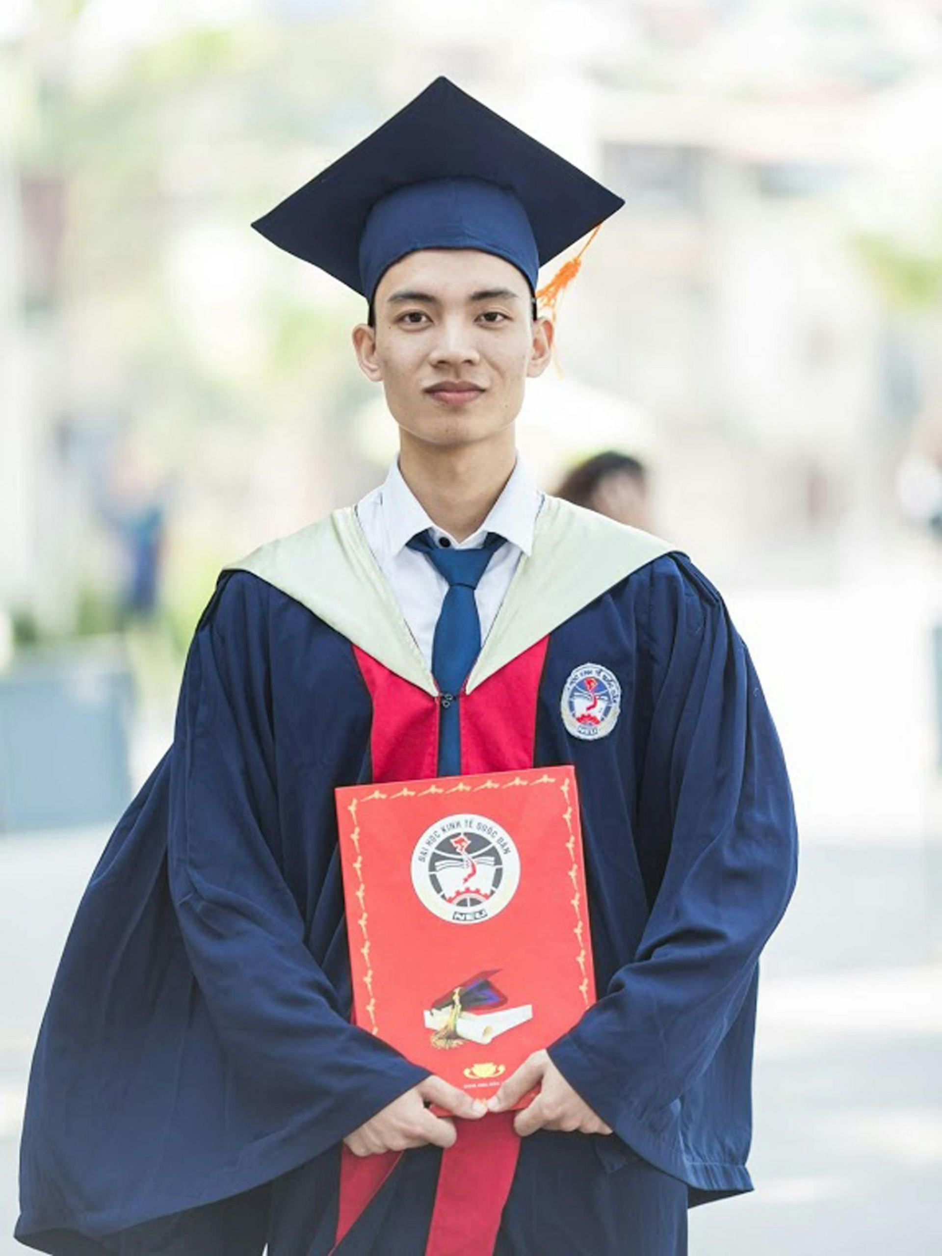 Ballerina en pointe, arms outstretched, wearing a flowing peach dress, backlit on a blue stage.