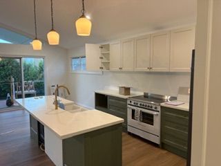 A kitchen featuring dark green lower cabinets and white upper cabinets — Channel Electrical In Swansea Heads, NSW