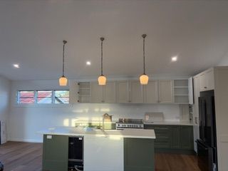 Modern kitchen with a white island and gray cabinets — Channel Electrical In Swansea Heads, NSW