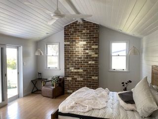 A bedroom with a slanted, white-paneled ceiling — Channel Electrical In Swansea Heads, NSW