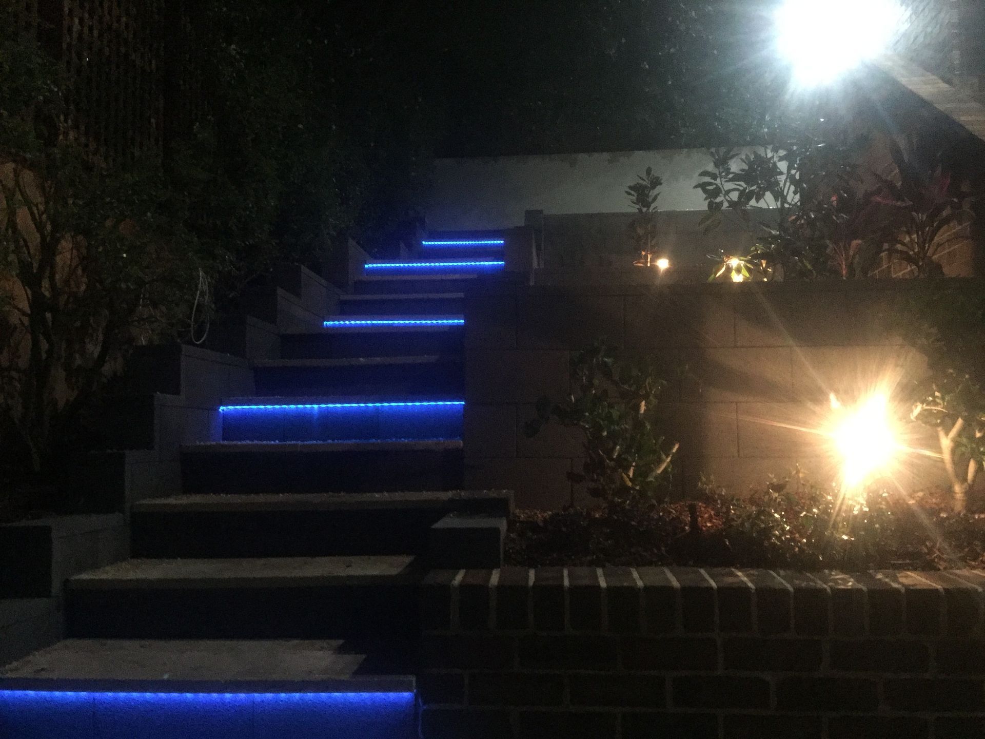 Outdoor stone steps at night, illuminated by bright blue LED strips — Channel Electrical In Swansea Heads, NSW
