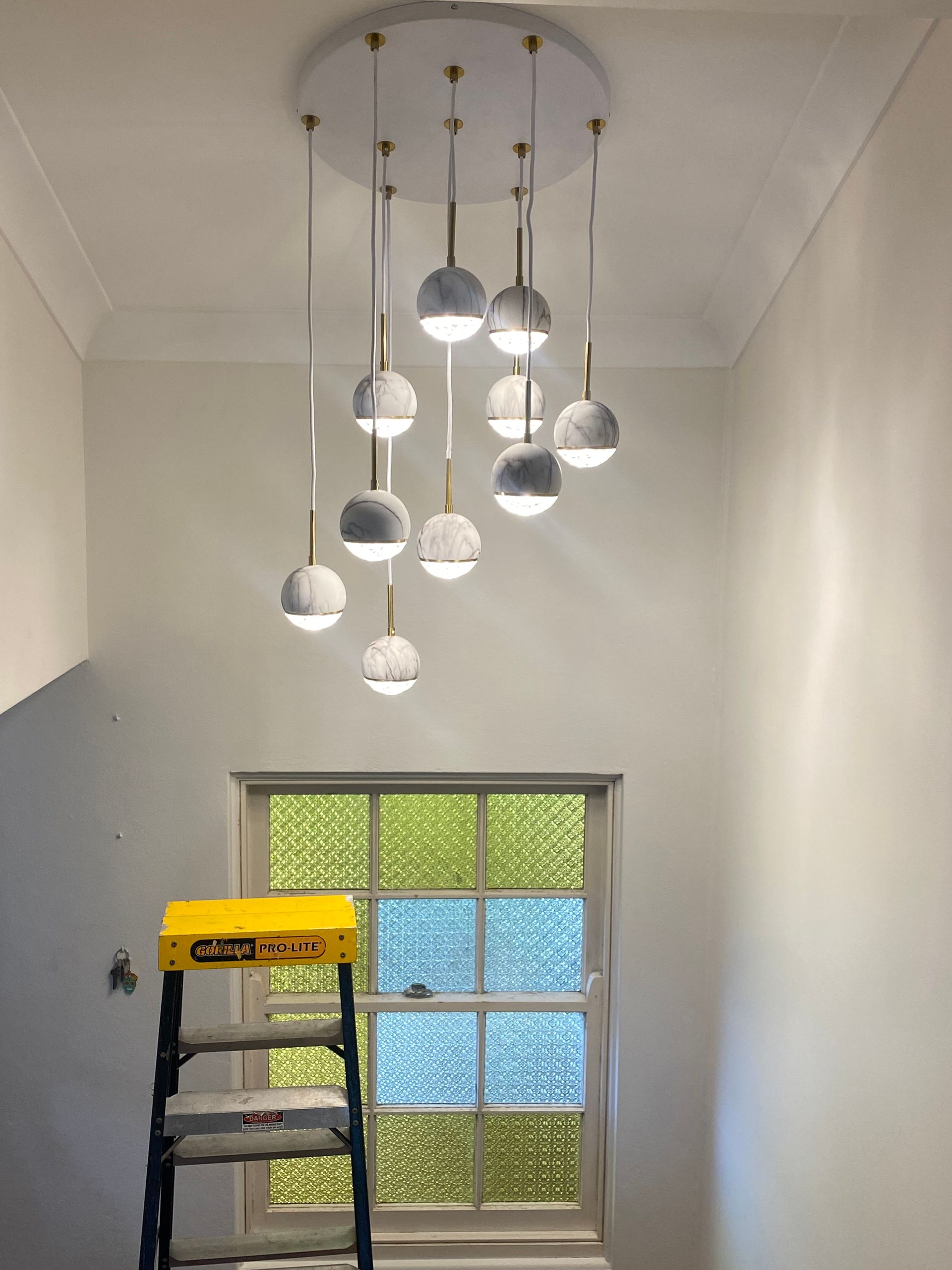 A multi-tiered, modern globe chandelier with marble-textured lights — Channel Electrical In Swansea Heads, NSW