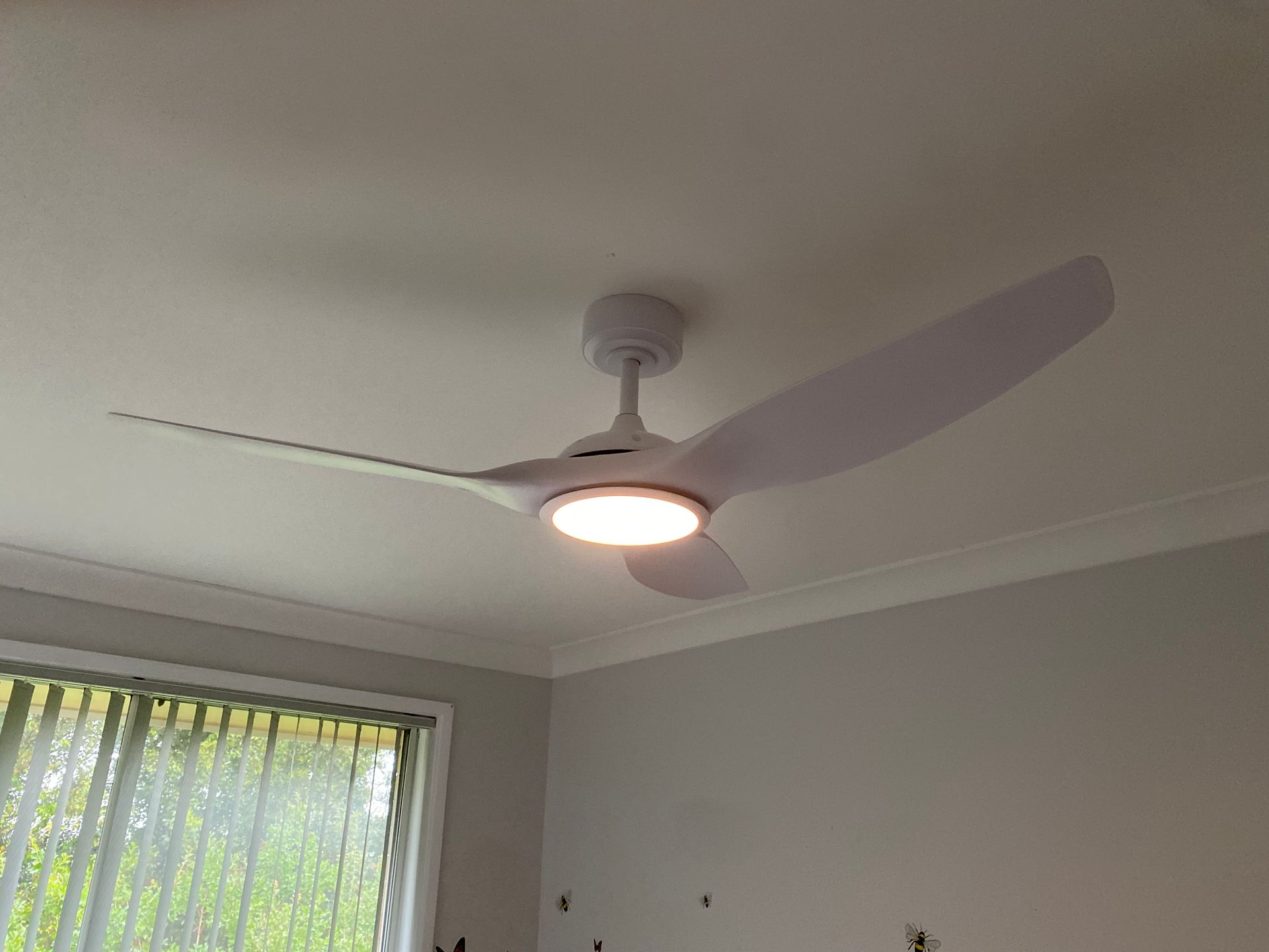 A modern white ceiling fan with three blades and a glowing circular LED light — Channel Electrical In Swansea Heads, NSW