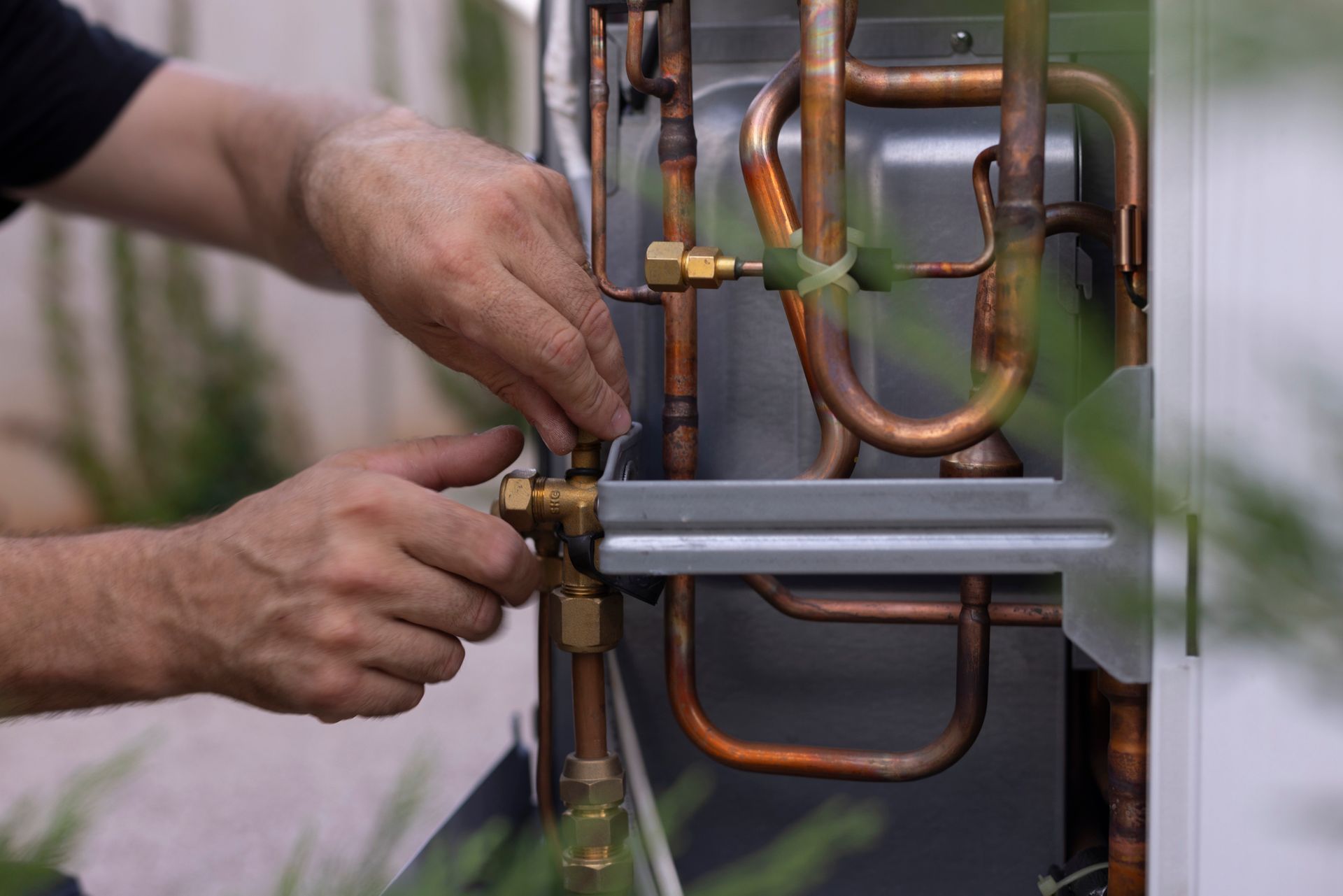 A man is working on a machine with copper pipes.