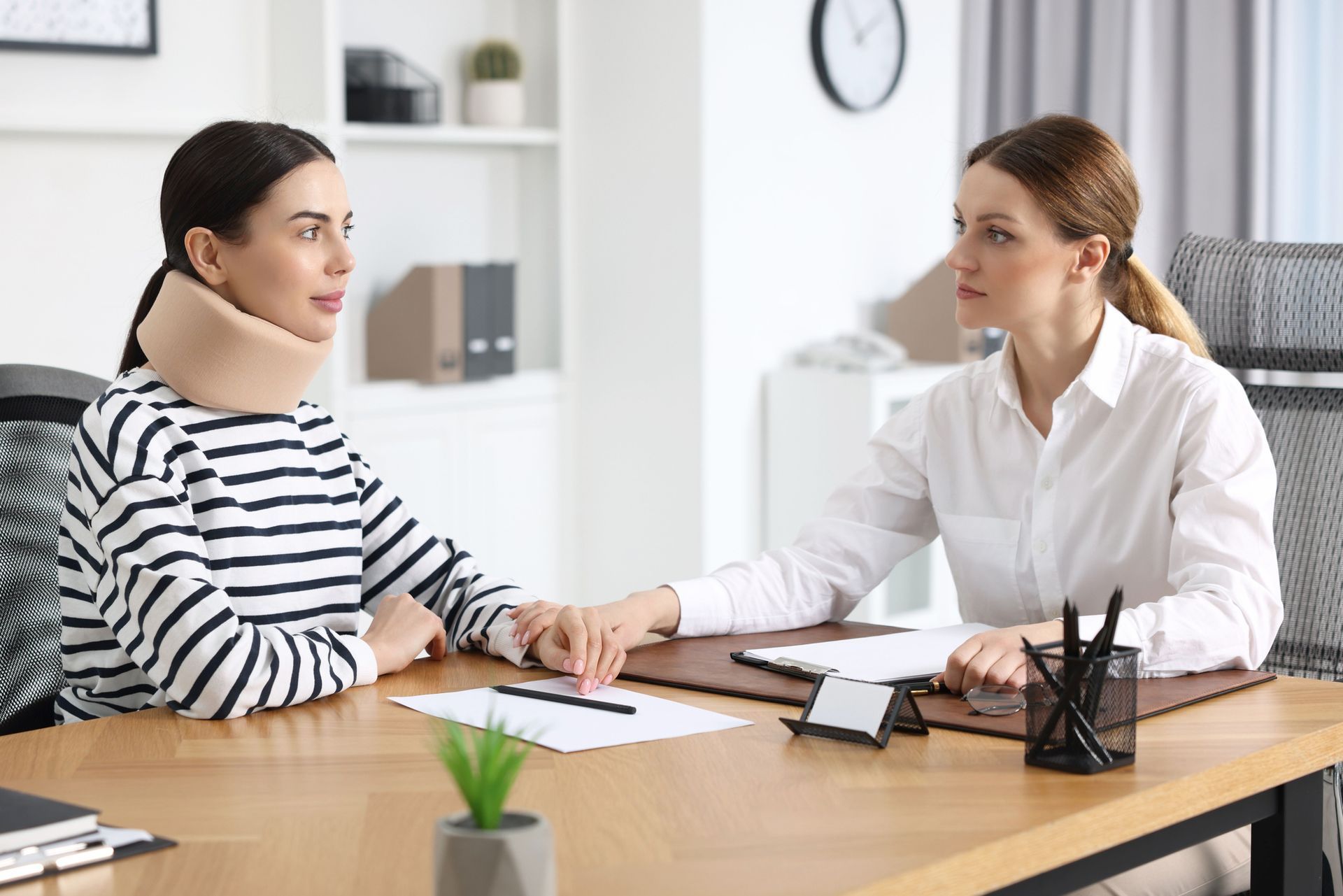 An injured woman is having a meeting with a lawyer in an office.