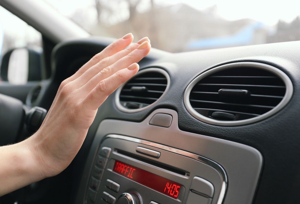 A Person Is Adjusting The Air Conditioner In A Car — Tim Warren Auto Airconditioning & Electrical In Bowen, QLD