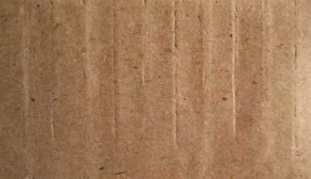 Brown corrugated cardboard, textured with vertical lines.