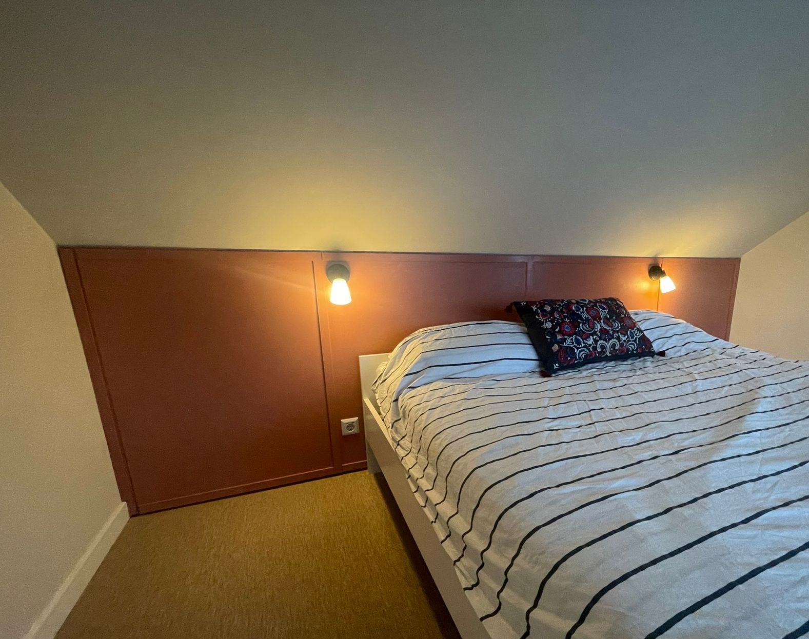 Een slaapkamer met maatwerk knieschotten en verlichting.