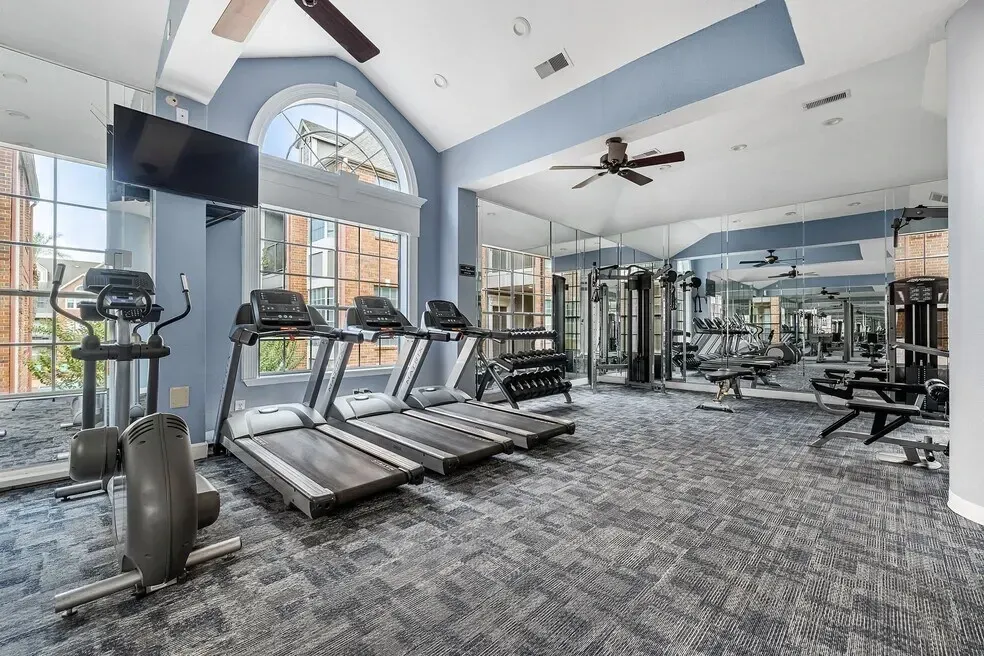 Fitness center with treadmills, elliptical, weight machines, and free weights.