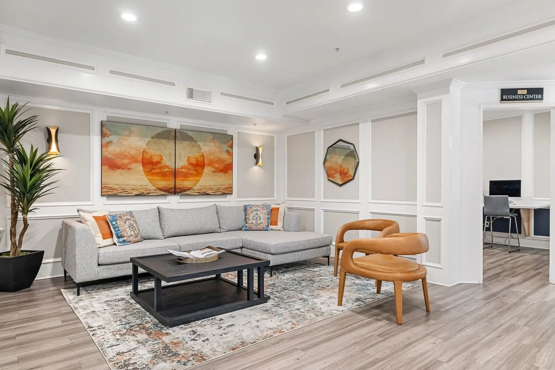 Lounge area with sectional sofa, coffee table, chairs, and artwork.