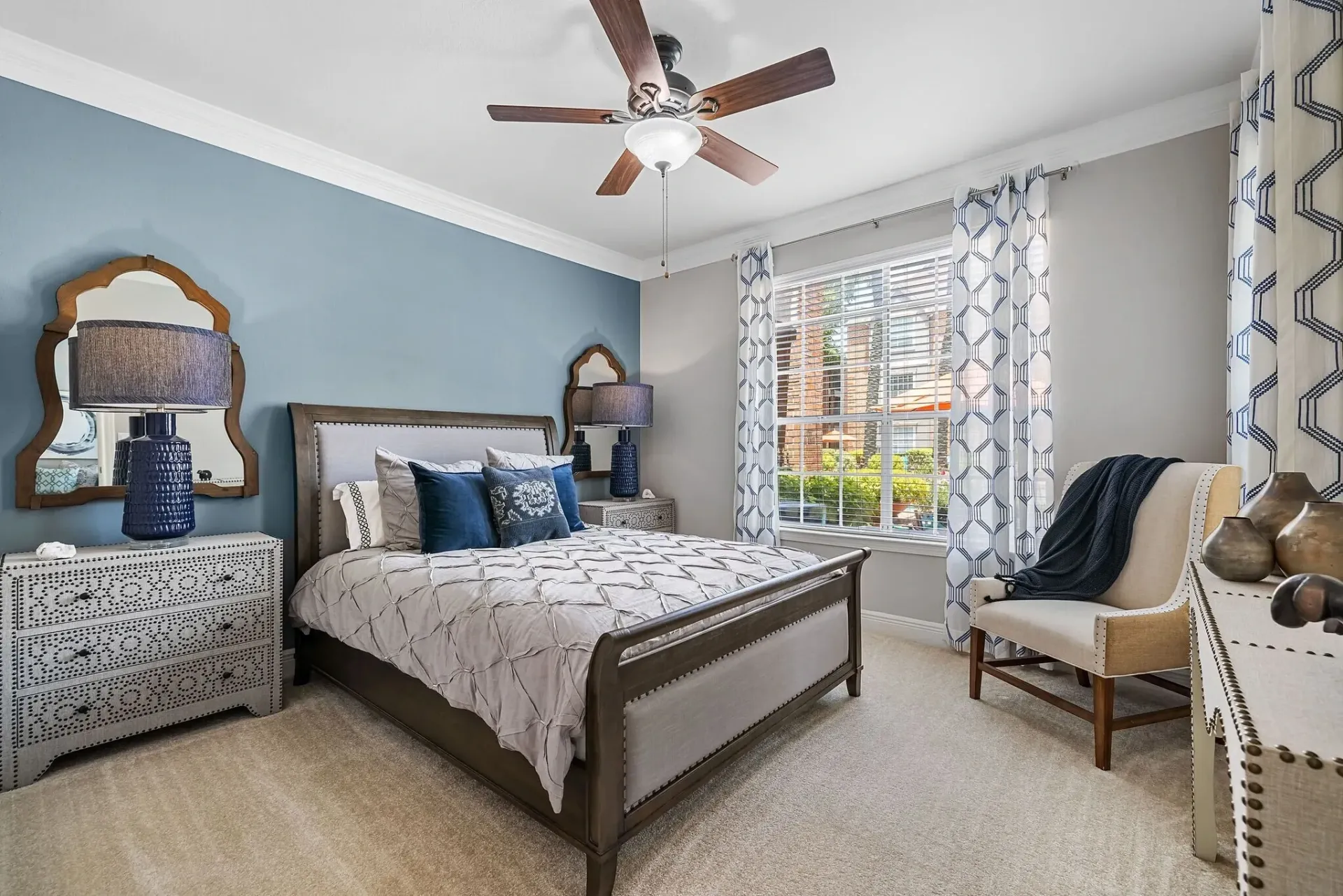 Bedroom with a king-size bed, dresser, and armchair.