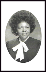 Judge wearing black robe and white bow. Oval portrait.