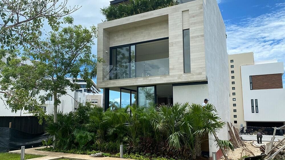 Una gran casa blanca con muchas ventanas y árboles frente a ella.