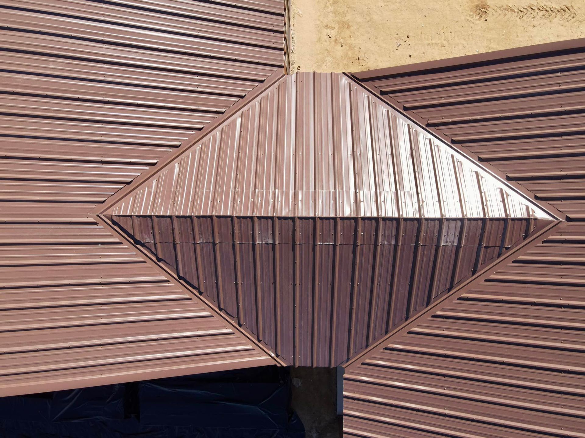 Diamond-shaped brown roof section where horizontal metal siding converges.