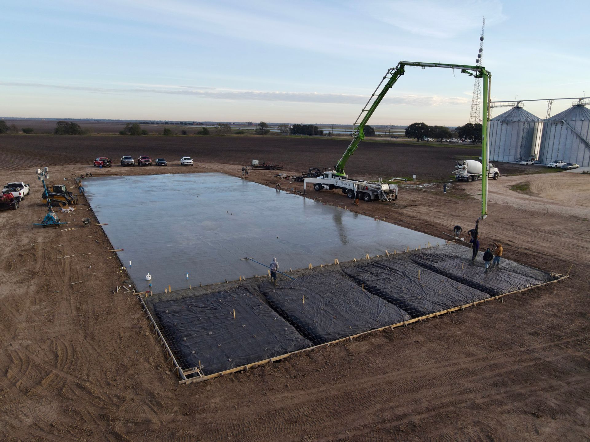 Dilapidated metal shed with a red-framed overhang on a grassy area under a cloudy sky.