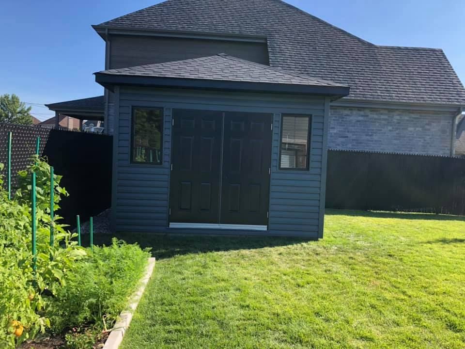 Un petit hangar se trouve dans l'arrière-cour d'une maison.