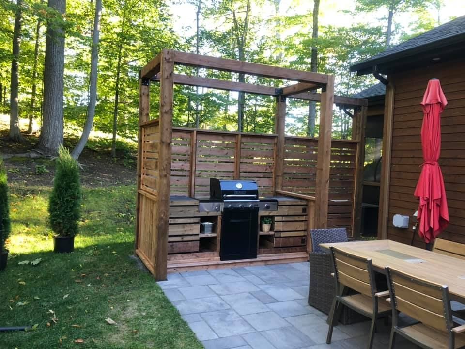 Un patio avec une table, des chaises et un grill