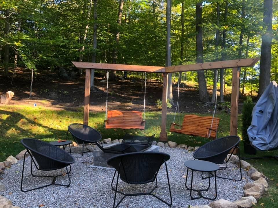 Un foyer entouré de chaises et de tables dans une cour arrière.