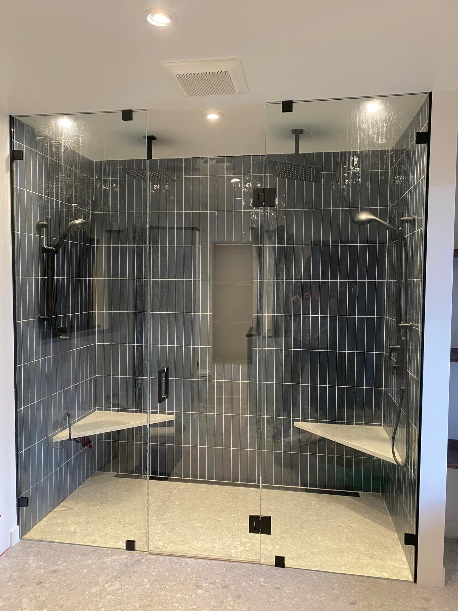 Une salle de bain avec douche à l'italienne et porte vitrée.