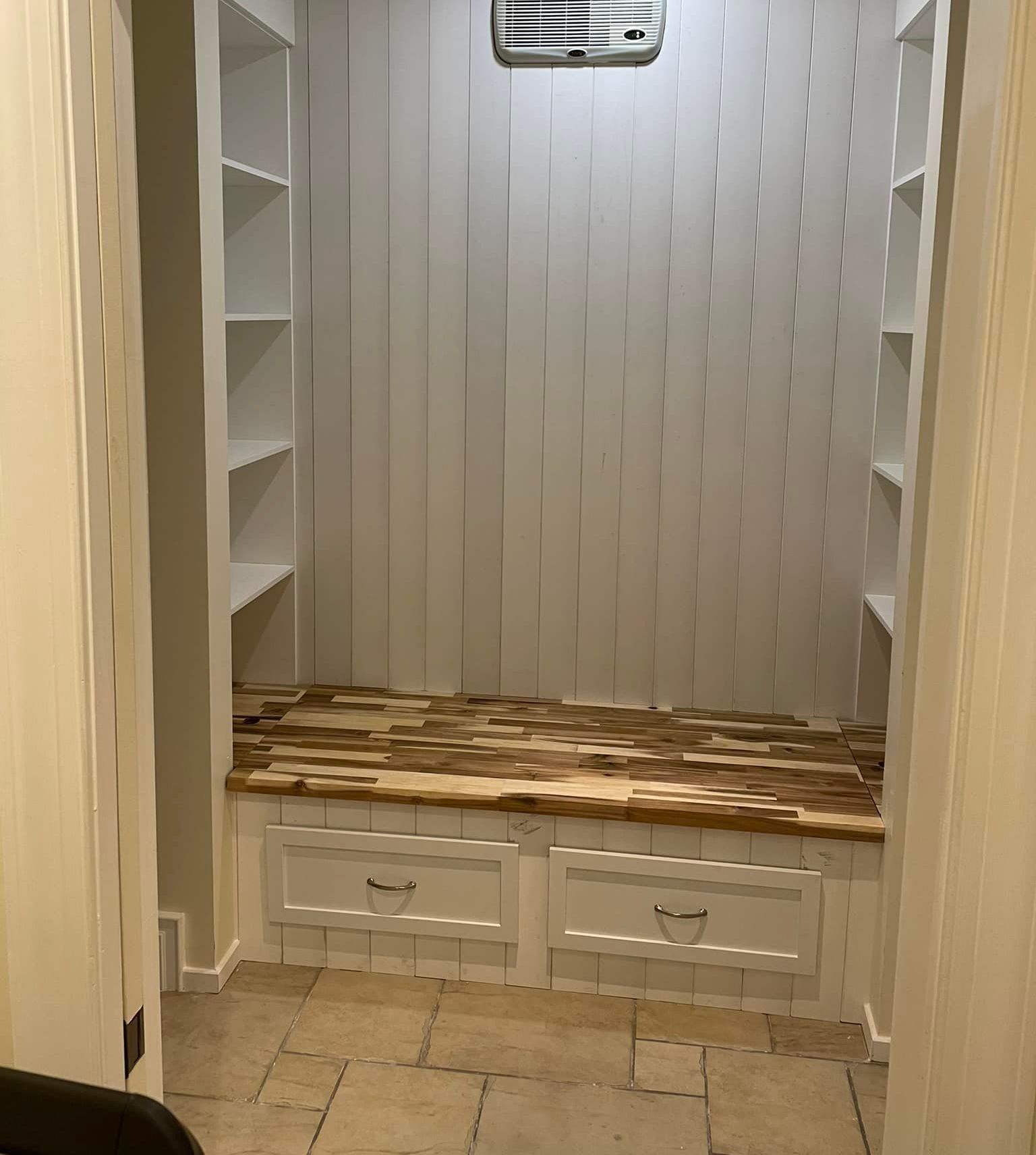 Un dressing avec un banc en bois et des étagères