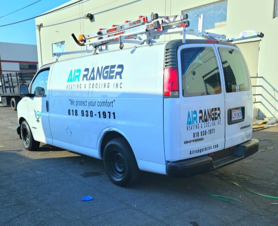 A white air ranger van is parked in front of a building