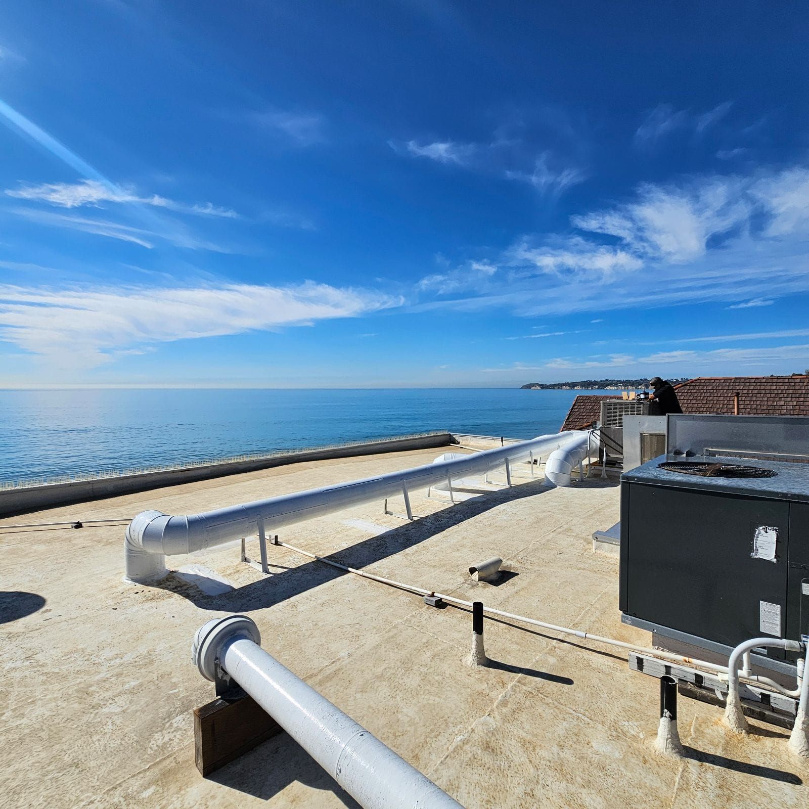 A rooftop with a view of the ocean on a sunny day