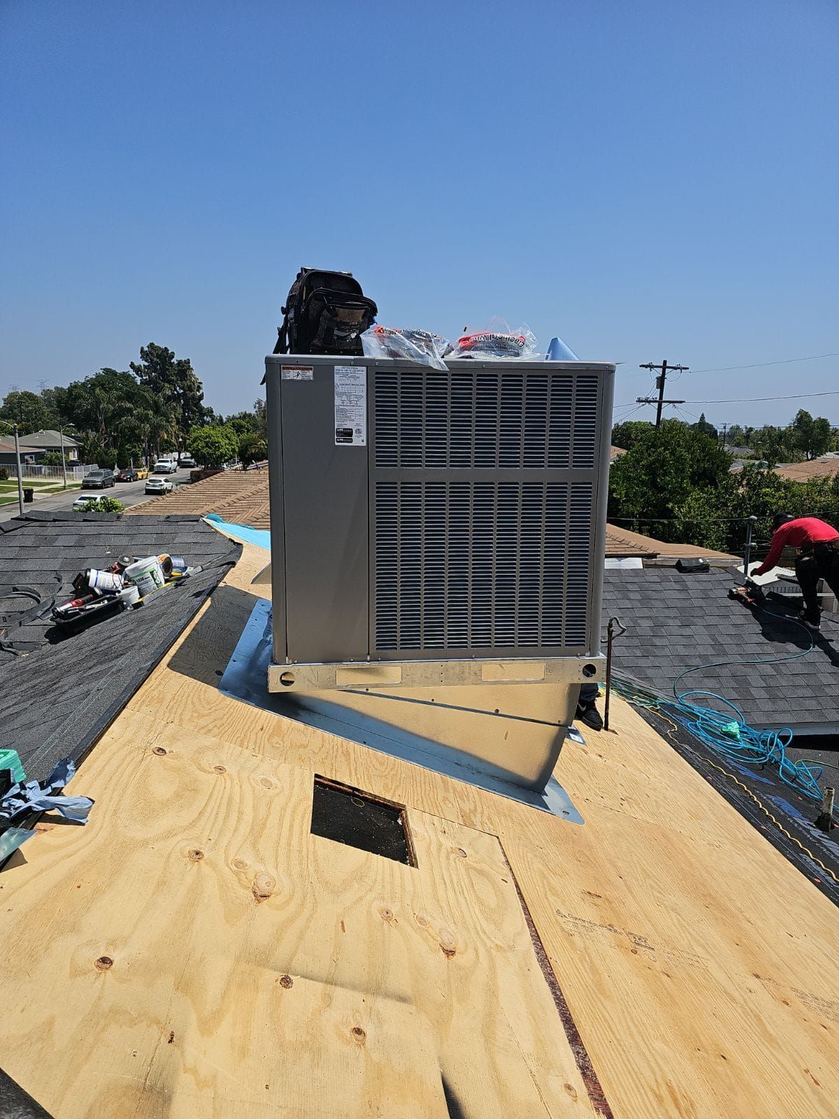 A large air conditioner is sitting on top of a wooden roof.