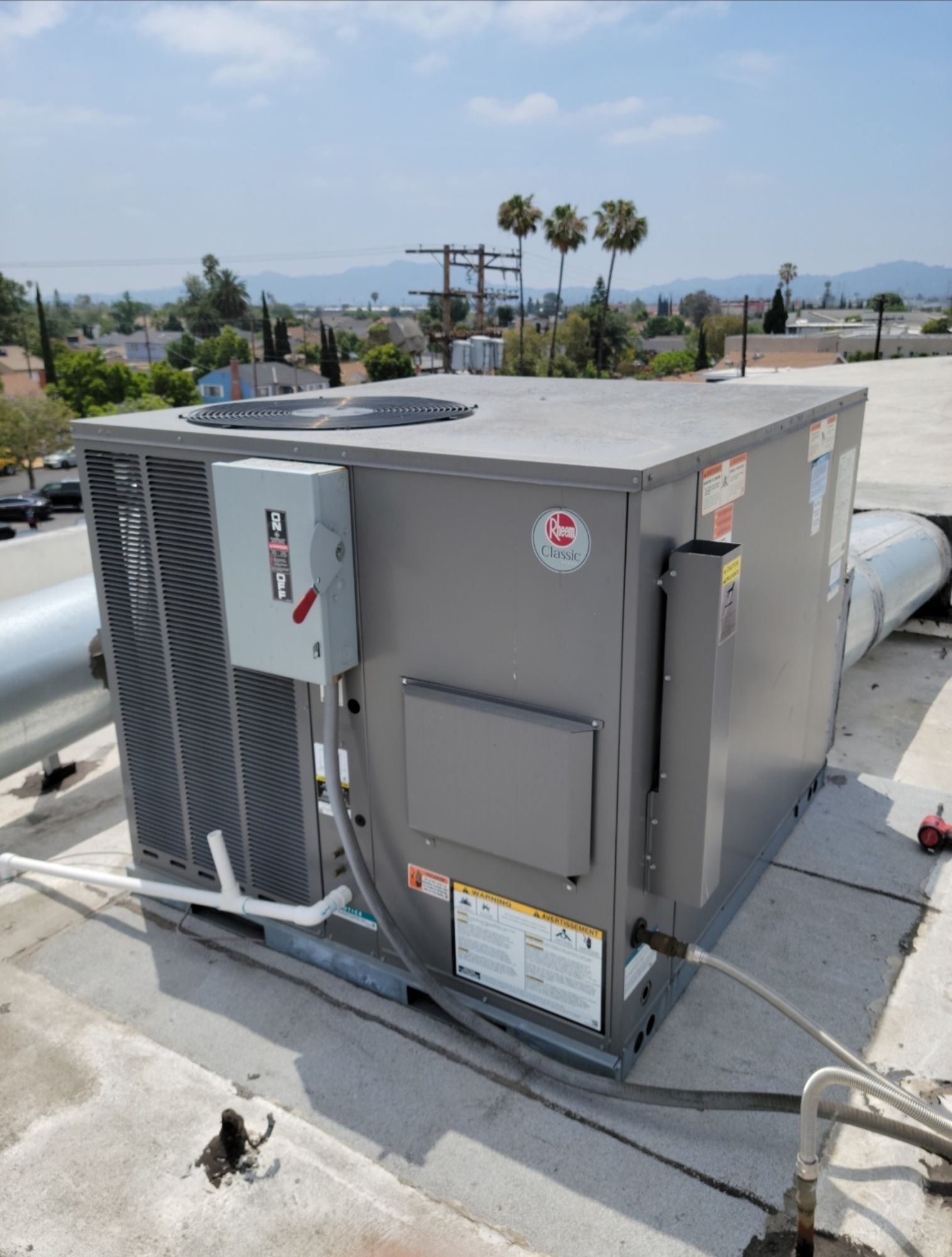 A large air conditioner is sitting on top of a roof.