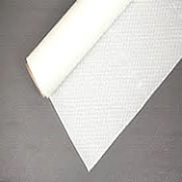 A roll of white fabric is sitting on a gray surface.