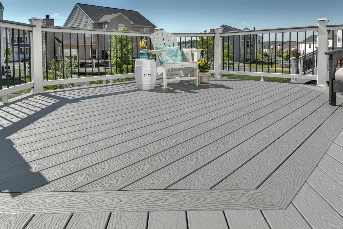 Trex® Decking from Budget Home Supply Colorado - Gray composite deck with white railings, black balusters, and outdoor furniture.