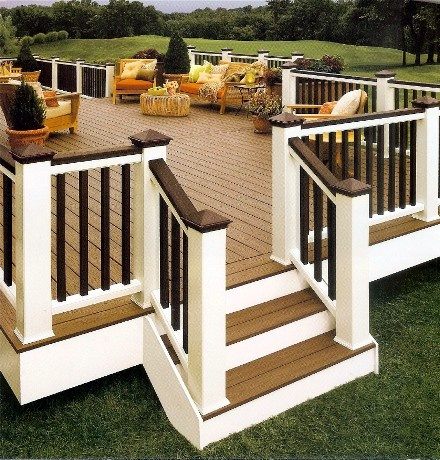 A deck with a white railing and stairs leading up to it