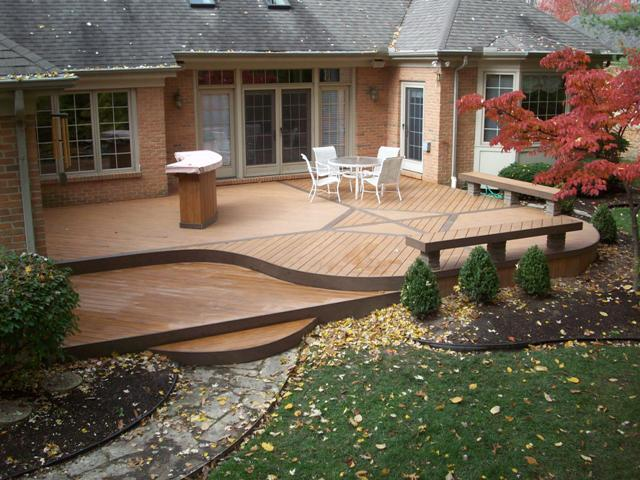 A patio with a table and chairs in front of a brick house