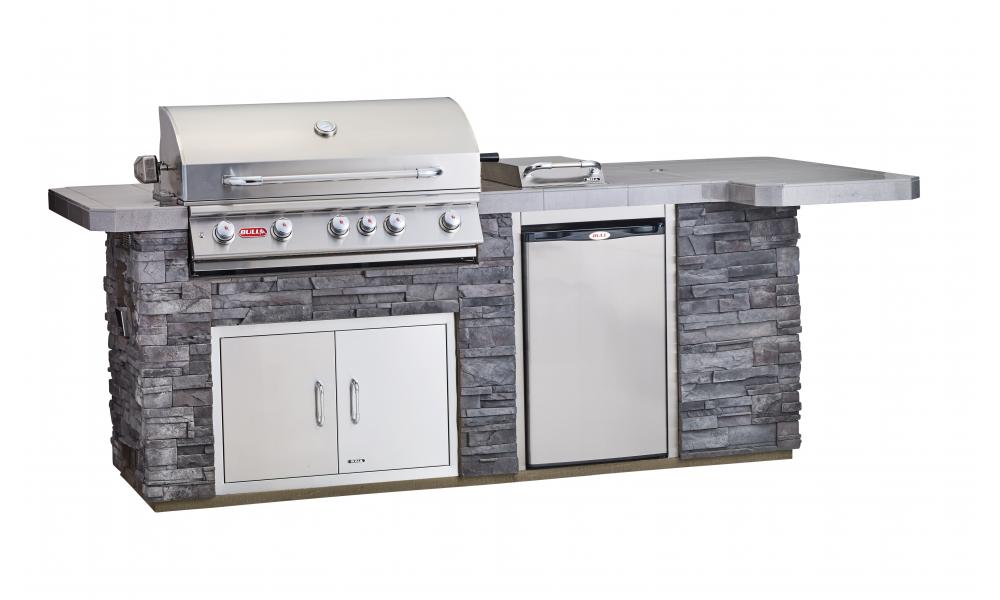 A stainless steel grill is sitting on top of a stone counter.