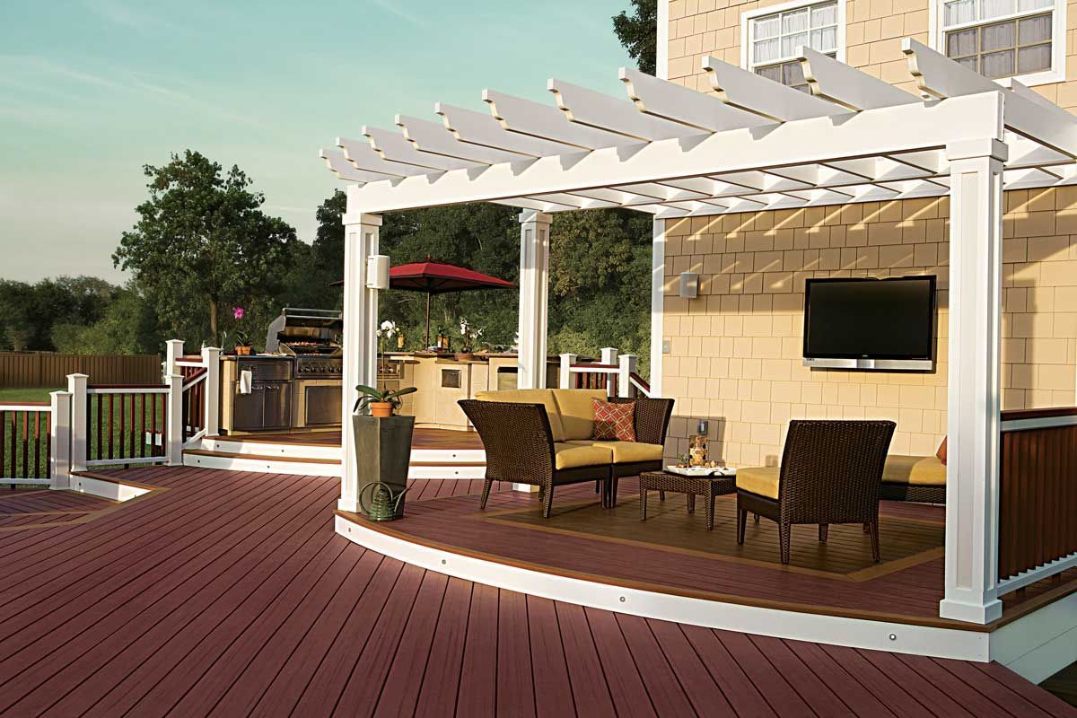 Trex® Decking from Budget Home Supply Colorado - Outdoor patio with pergola, seating area, built-in grill, and a mounted TV.