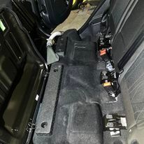 The back seat of a car with the trunk open.