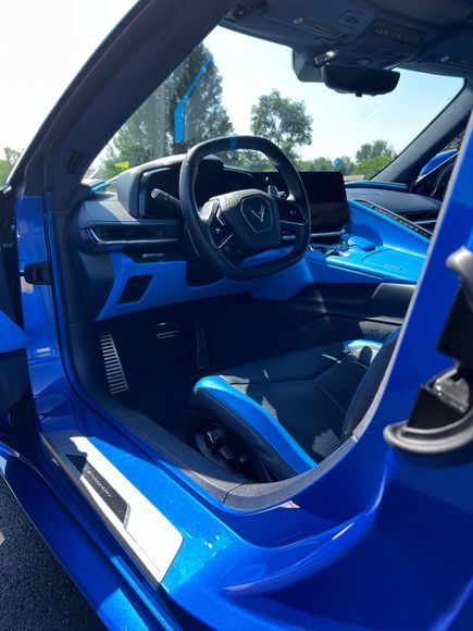 The inside of a blue sports car with the door open