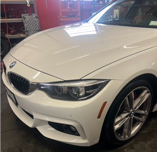 A white bmw is parked in a garage