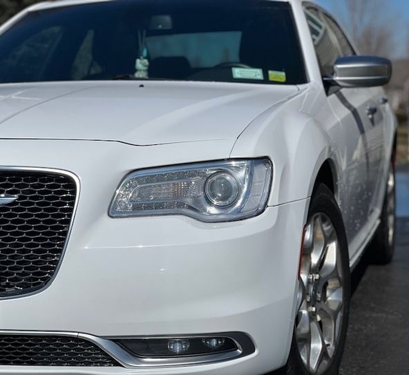 A white car is parked on the side of the road