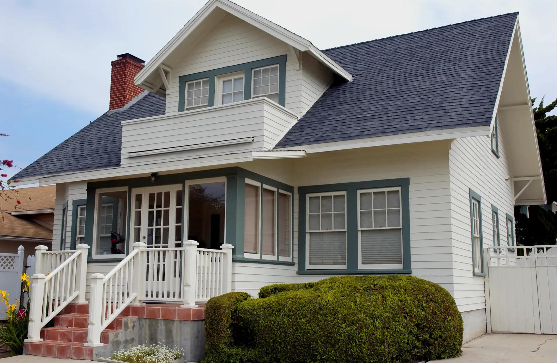 A white house with a blue roof and green trim