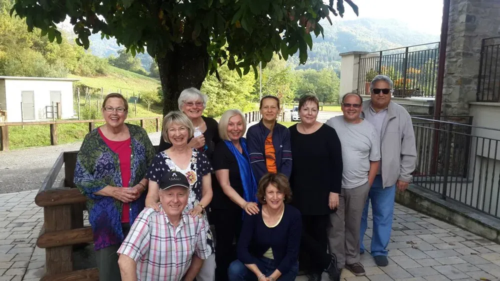 Group photo under a tree in the Apennine foothills, smiling with fresh mountain air and rustic charm.