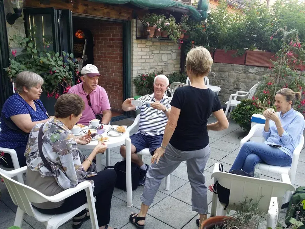 Group enjoying breakfast and conversation on a garden patio.