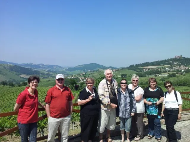 Tour group posing with vineyard views.