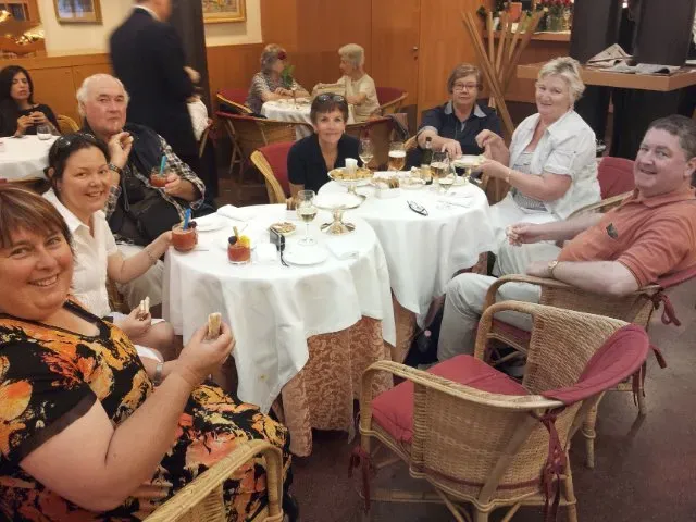 A cheerful group enjoying drinks and desserts at a cozy café.