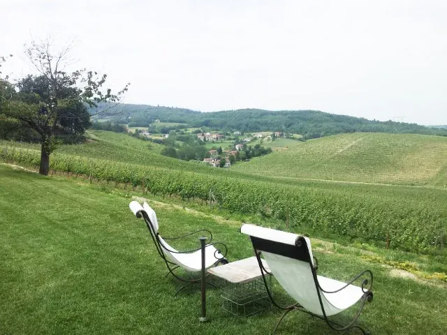 Two lounge chairs overlook rolling vineyard hills—peaceful countryside escape.