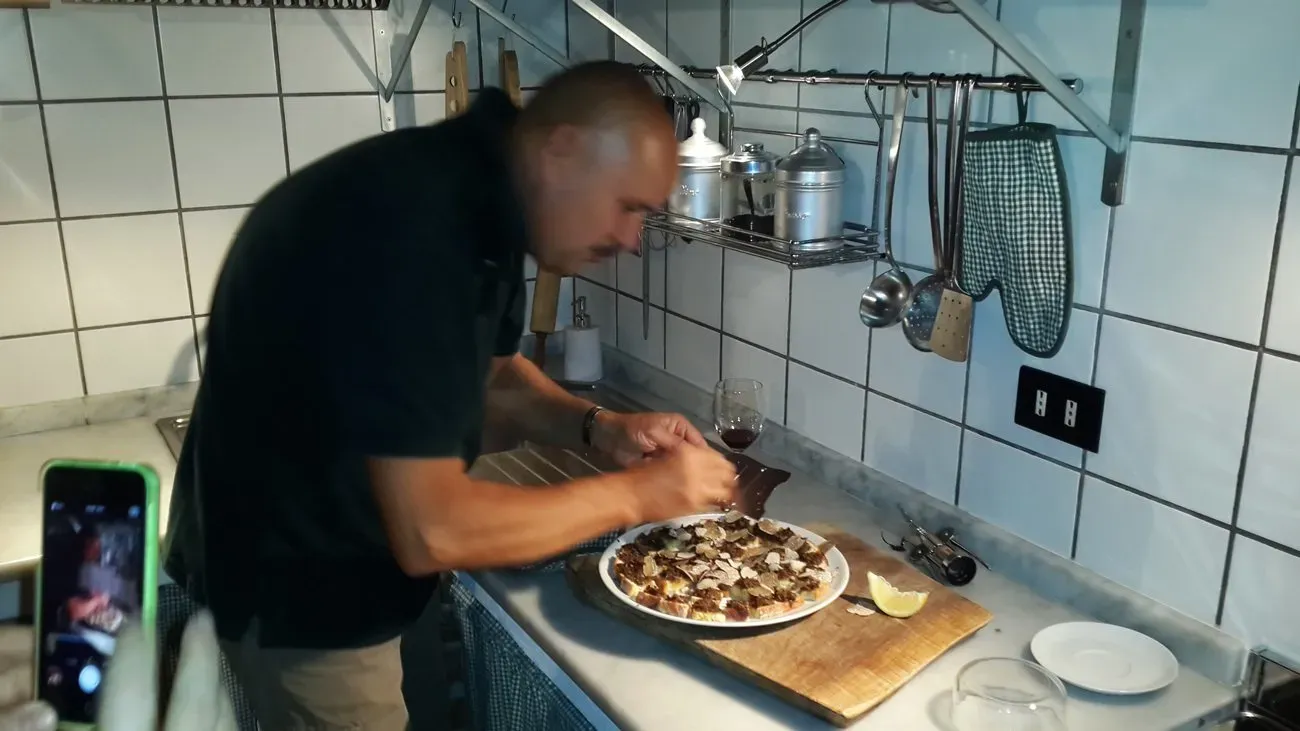 Man preparing truffle dish in a kitchen.