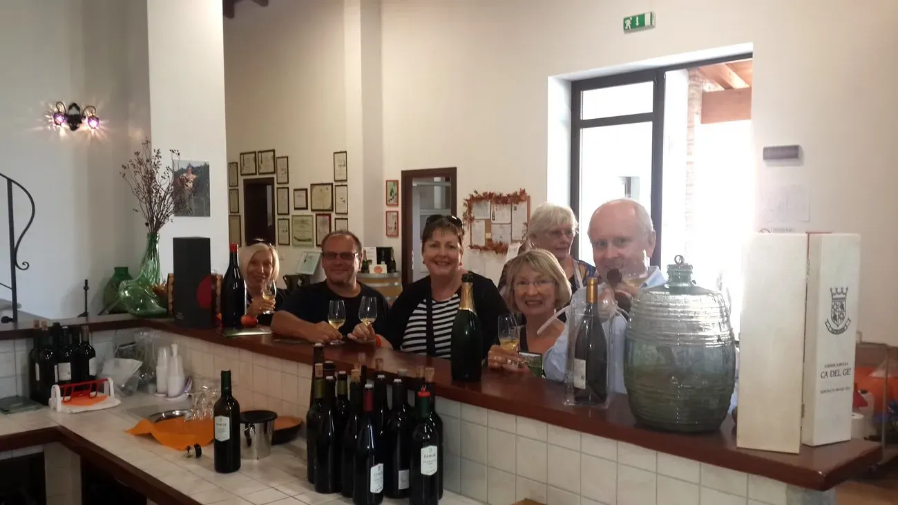 Wine tasting group at a bar, smiling with glasses.