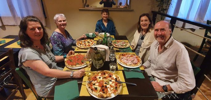 A group of people are sitting at a table eating pizza.