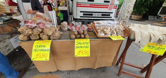 A table with a lot of food on it and a truck in the background.